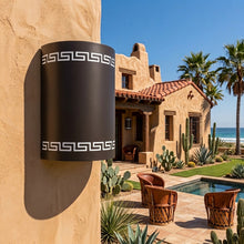 Load image into Gallery viewer, Greek key wall sconce in oil-rubbed bronze, mounted on a stucco wall beside a tiled-roof courtyard
